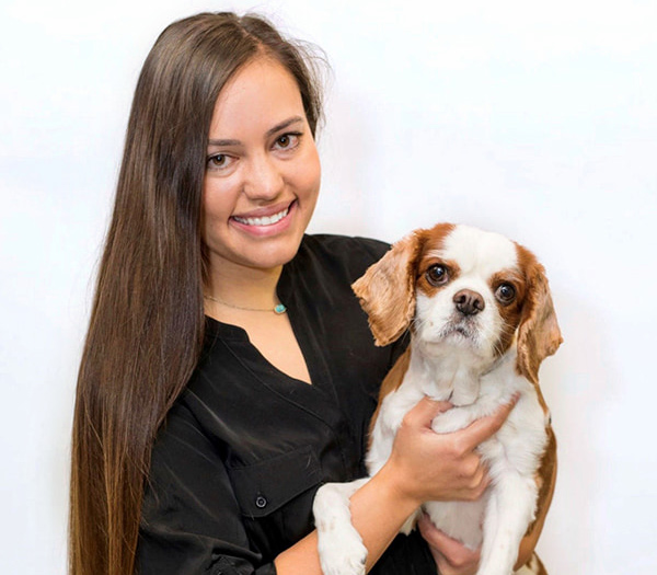 Michelle Hundt, DVM smiling holding a dog.
